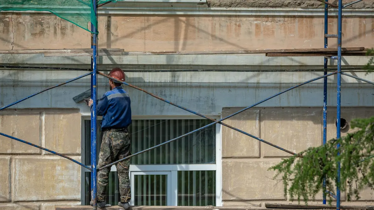 Ouvrier intervenant sur la façade d'un bâtiment en rénovation