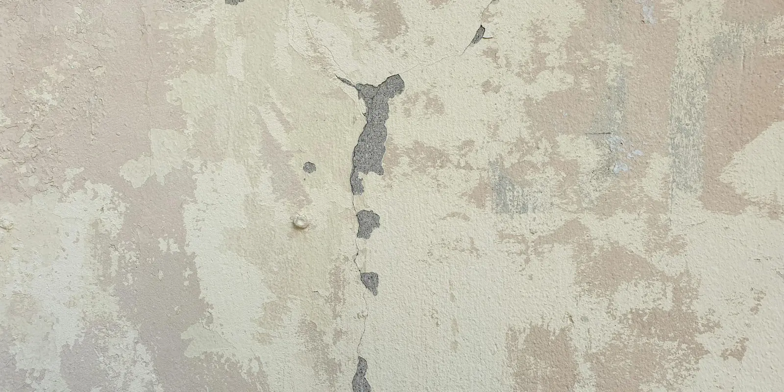 Mur ancien dégradé par l'humidité, enduit qui s'écaille