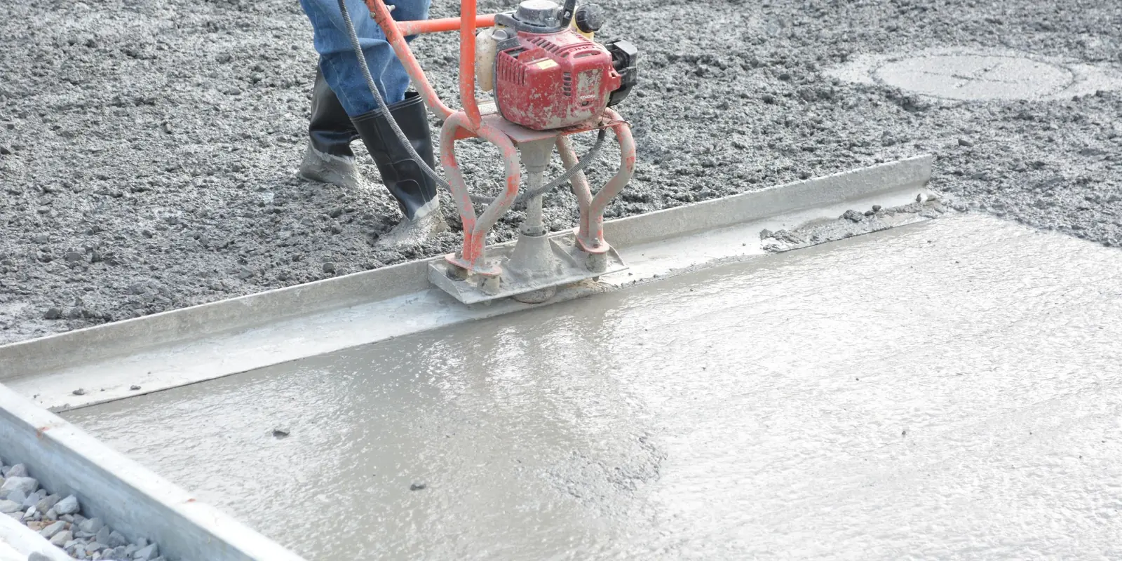 Lissage d'un sol en mortier frais sur un chantier